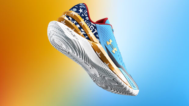 View of blue, gold, and white Under Armour shoe.